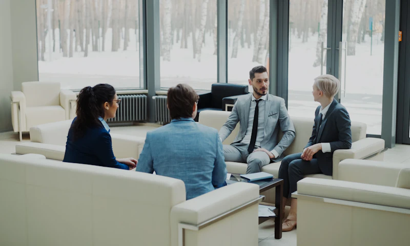 Four colleagues talking in a bright office meeting area